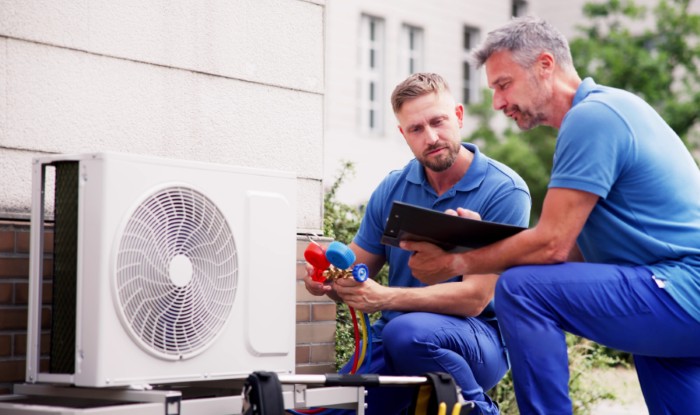 HVAC technicians reviewing an outdoor air conditioning unit in Avondale, AZ