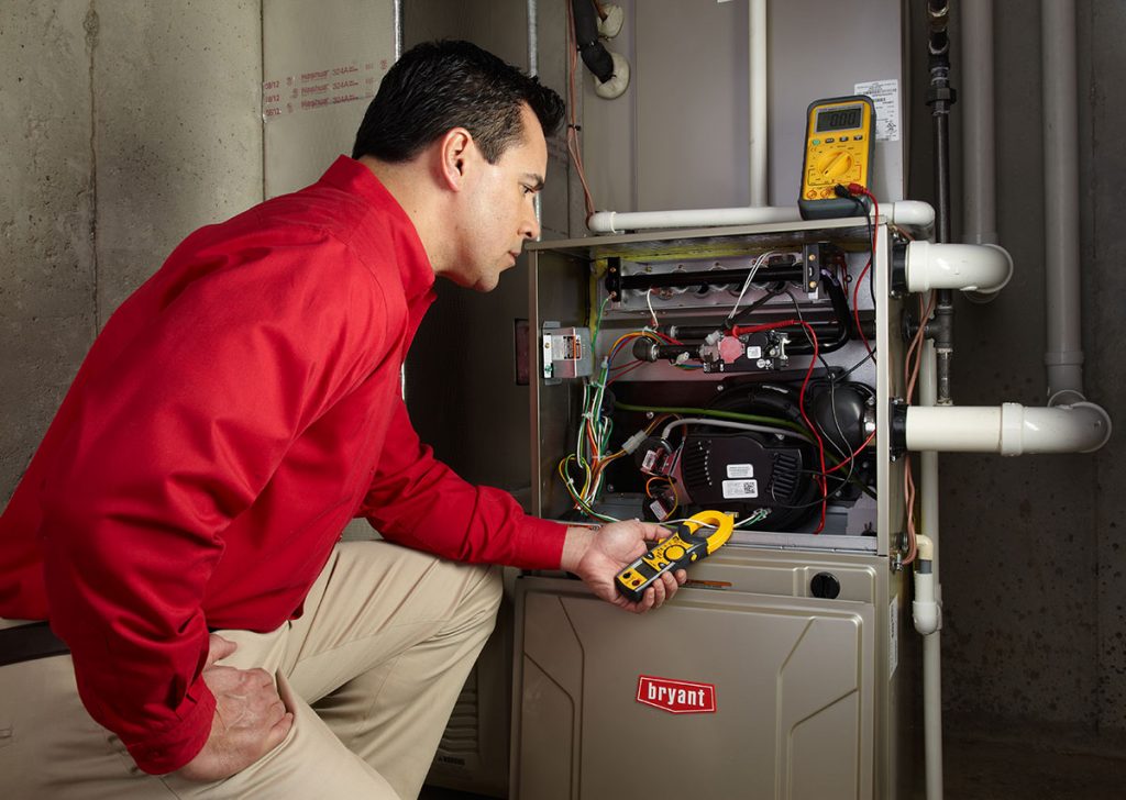 Heating and air conditioning technician servicing an indoor furnace in Avondale, AZ