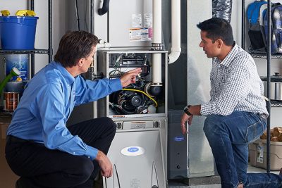 65df8c11f3e4c468cbd351a5_furnace repair vs replacement – Copy HVAC technician explaining furnace repair and maintenance to a homeowner in Avondale, AZ