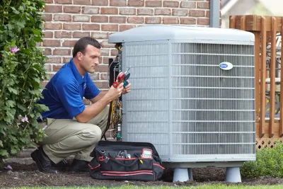design-air-heating-and-air-conditioning-decatur-il-05 – Copy HVAC technician inspecting an outdoor air conditioning unit in Avondale, AZ