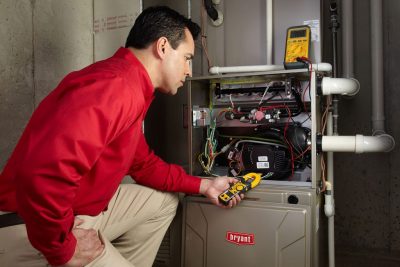 furnace repair Heating and air conditioning technician servicing an indoor furnace in Avondale, AZ